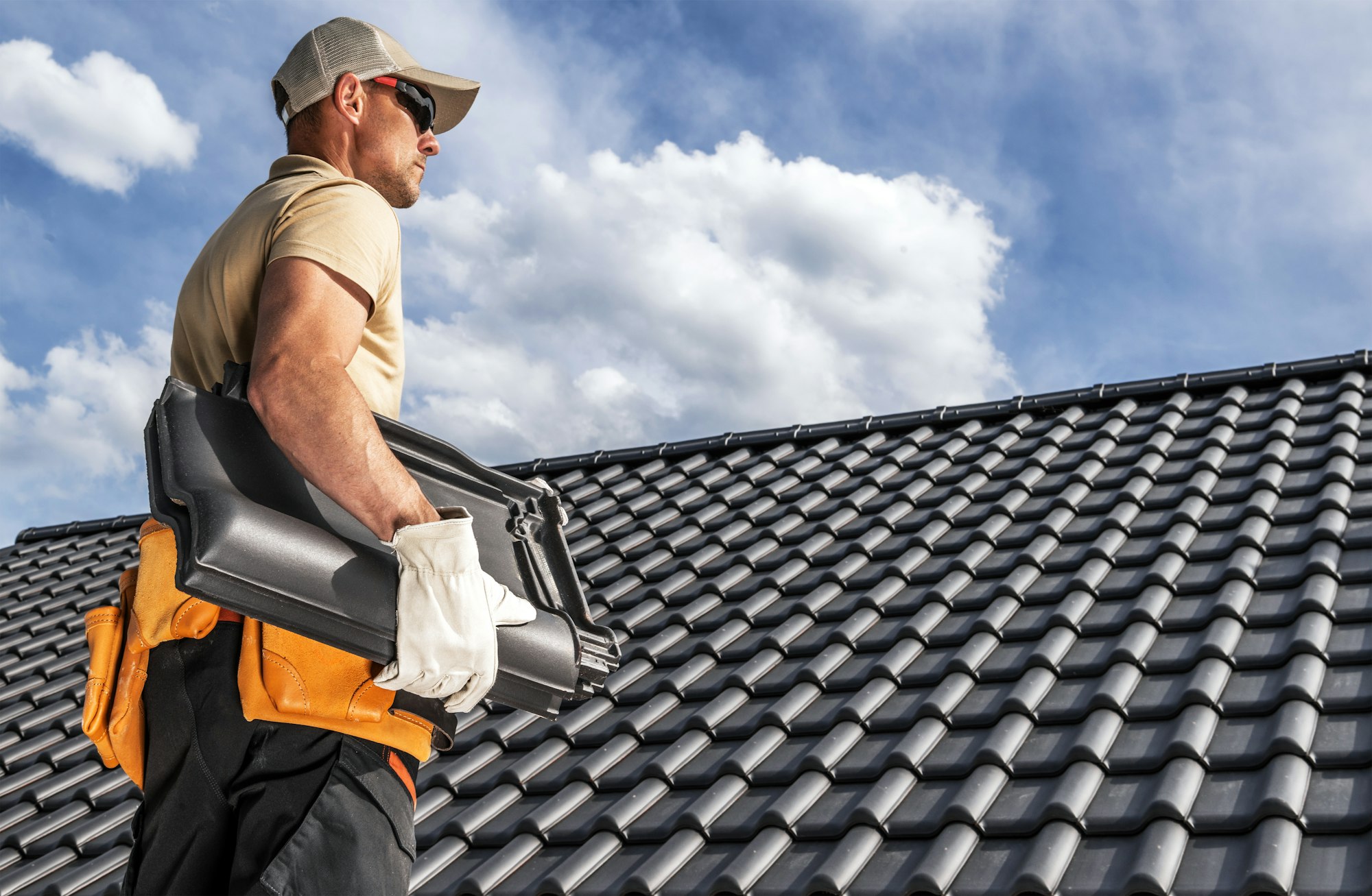 Roofing Worker with a Ceramic Roof Tiles in His Hands